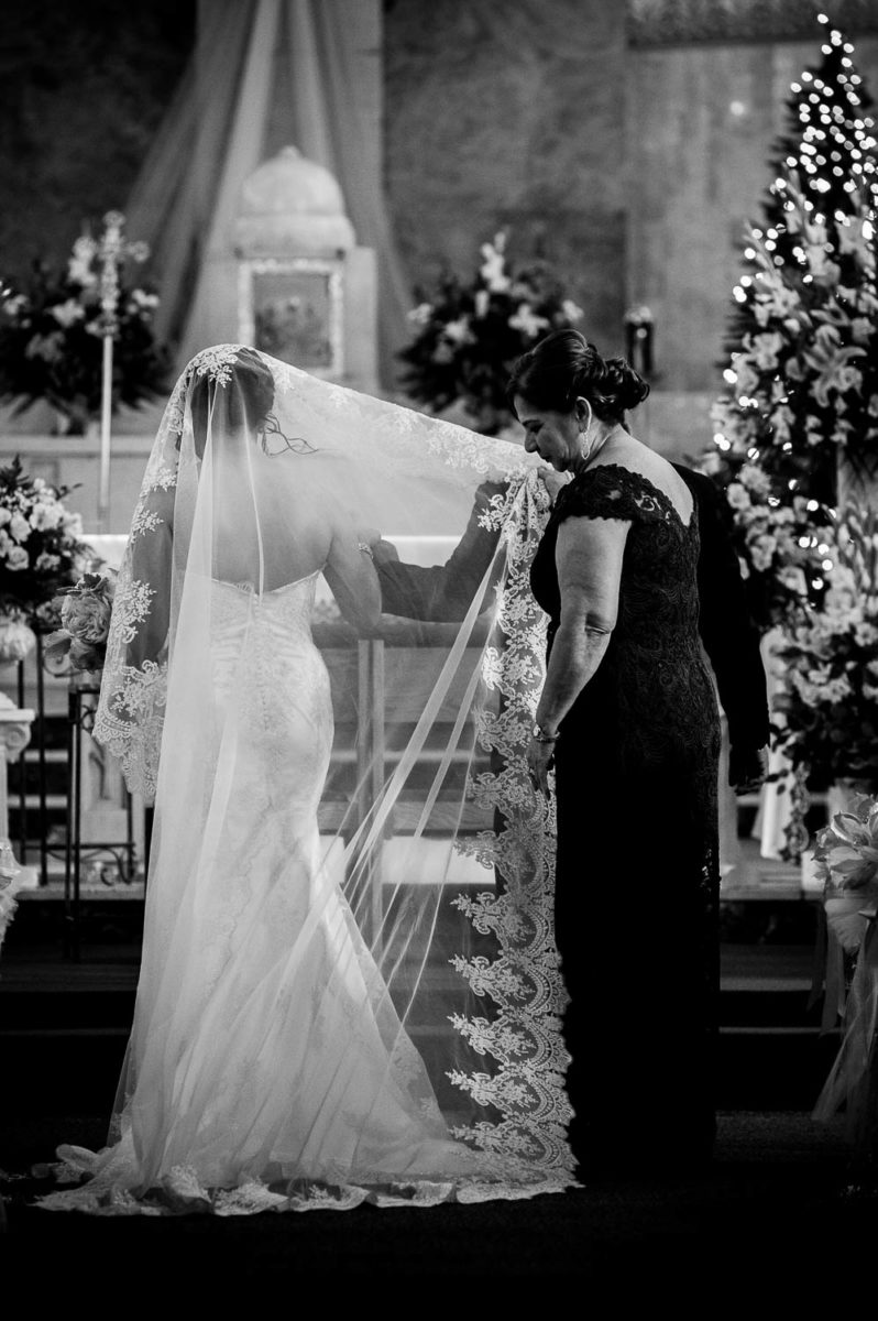 Brides helps set her veil during commencement of wedding ceremony at immaculate-heart-of-mary-church-philip-thomas-photography