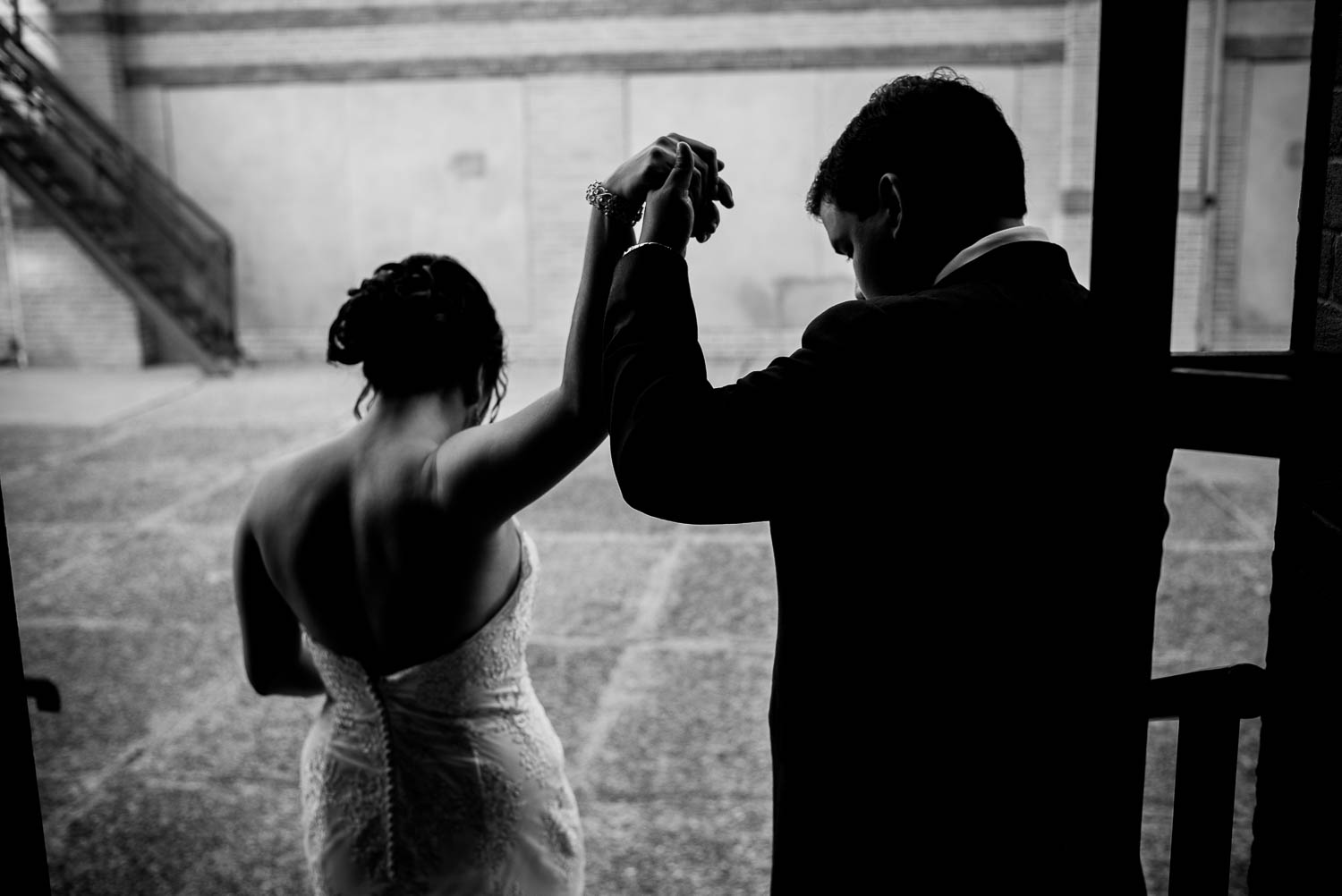 Shot from behind couple hold hands up high at immaculate-heart-of-mary-church-philip-thomas-photography