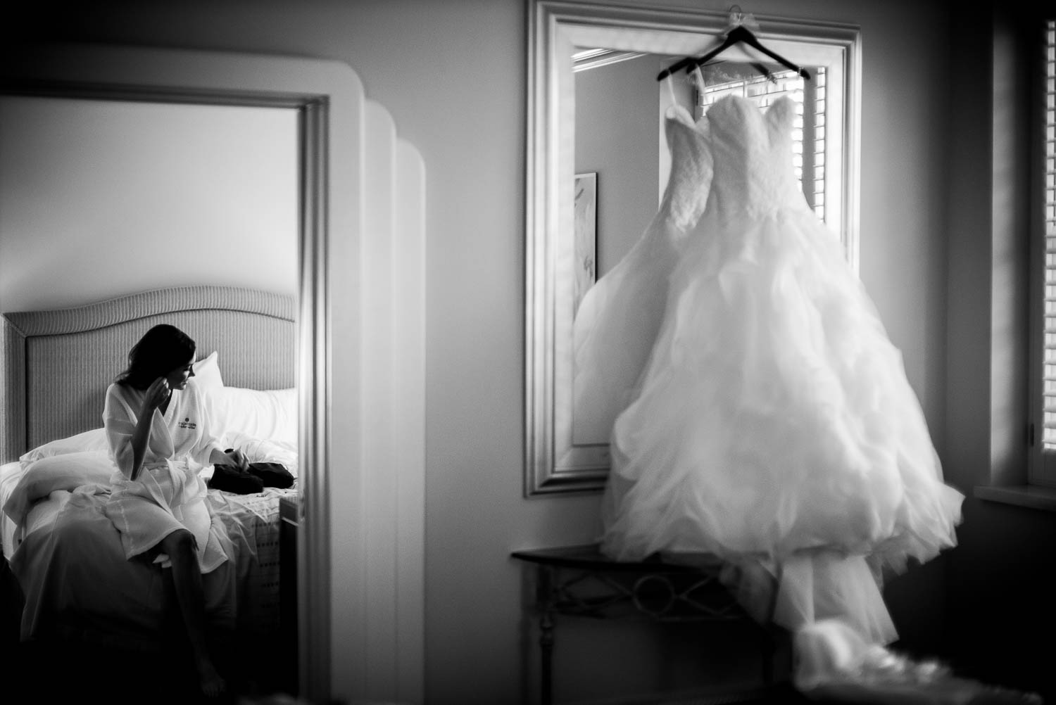 Bride wears earrings sitting in hotel room at Hotel Galvez Galveston Wedding in Texas