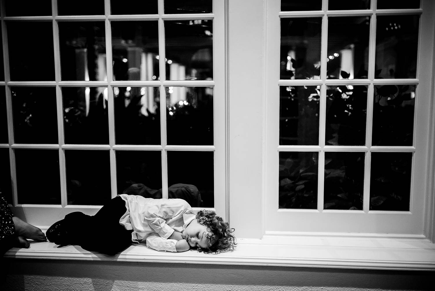 Little boy asleep is captured at wedding reception Hotel Galvez wedding reception in Corpus Christie, Texas. Photographed by Philip Thomas with a Leica M(240).