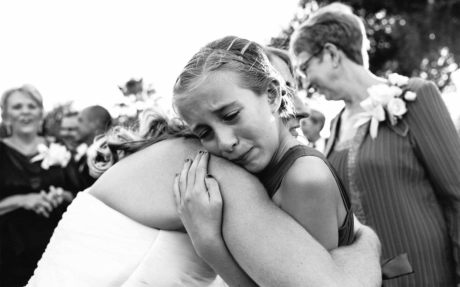 Emotion as flower girl hugs bride at a wedding reception in Corpus Christi, Texas. Leica wedding photographer