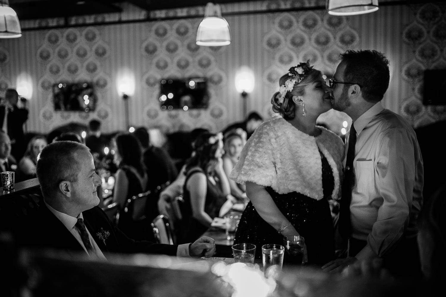 Bride and groom kiss as parents sit at Republic Takoma Park Washington D.C-Leica Wedding photographer-Philip Thomas