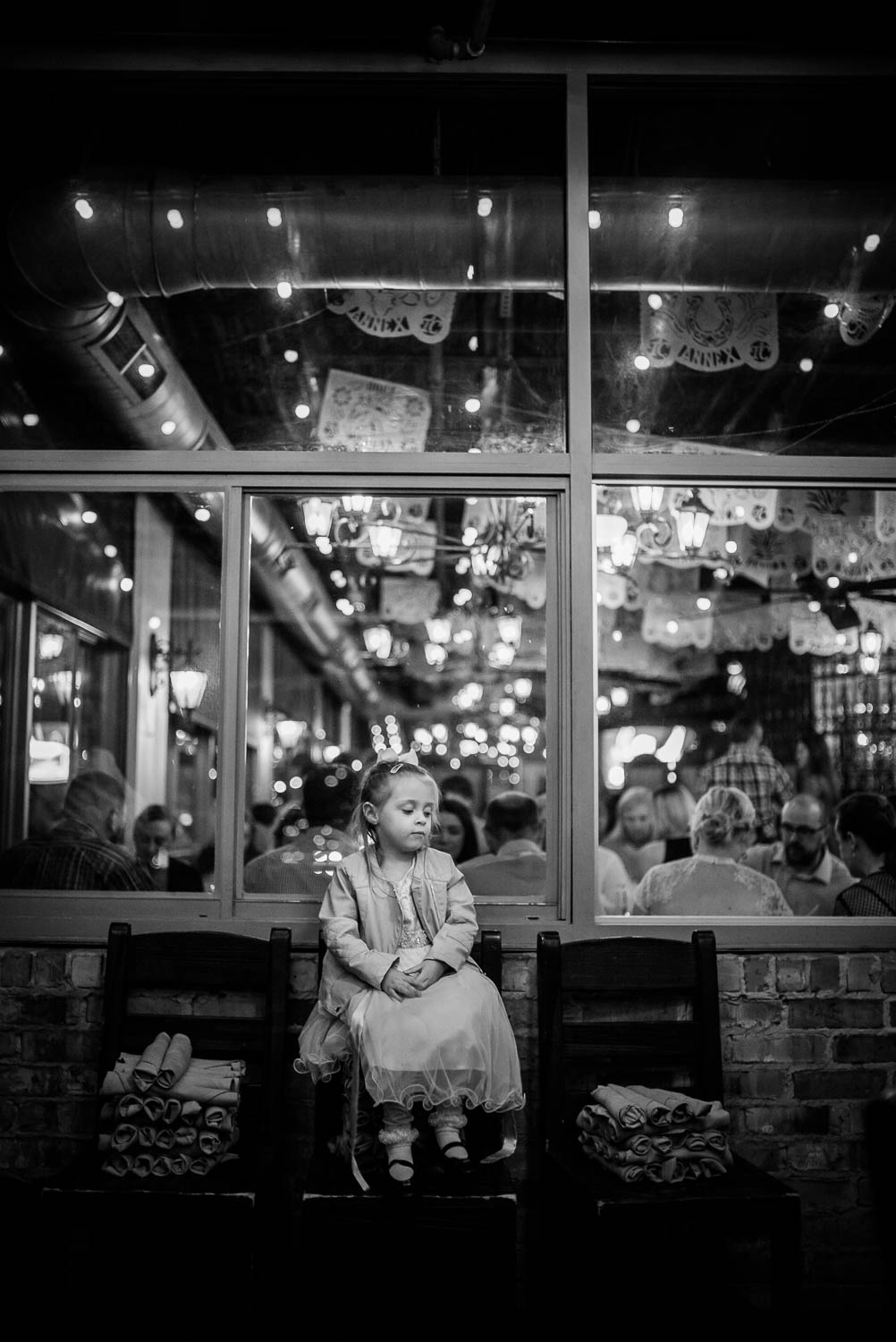 Little girl sits on a bench at a wedding rehearsal dinner El Tiempo Mexican restaurant