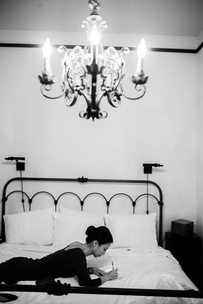 Brides sister writes her speech out on a bed at Hotel Havana -Leica photographer-Philip Thomas Photography