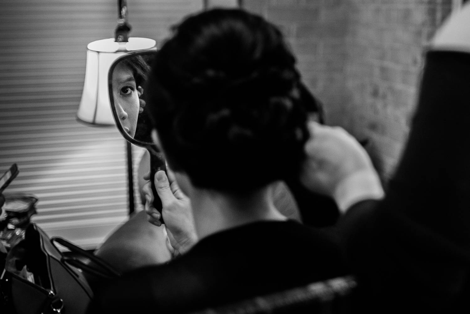 The bride has her hair and makep as bride looks in mirror at Hotel Havana -Leica photographer-Philip Thomas Photography