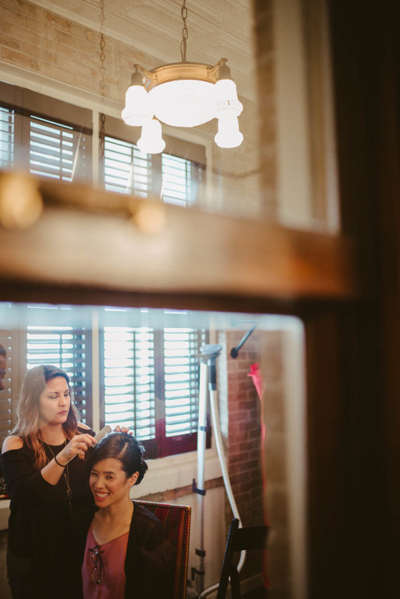 A hair stylists fixes her hair before brides wedding ceremony at Hotel Havana -Leica photographer-Philip Thomas Photography