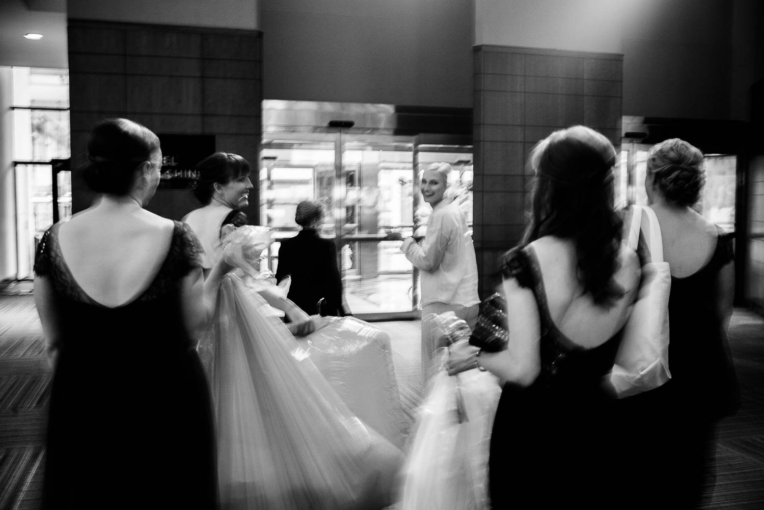 Movement shown as bride looks over her shoulder leaving Hyatt Regency Hotel, Houston Texas.