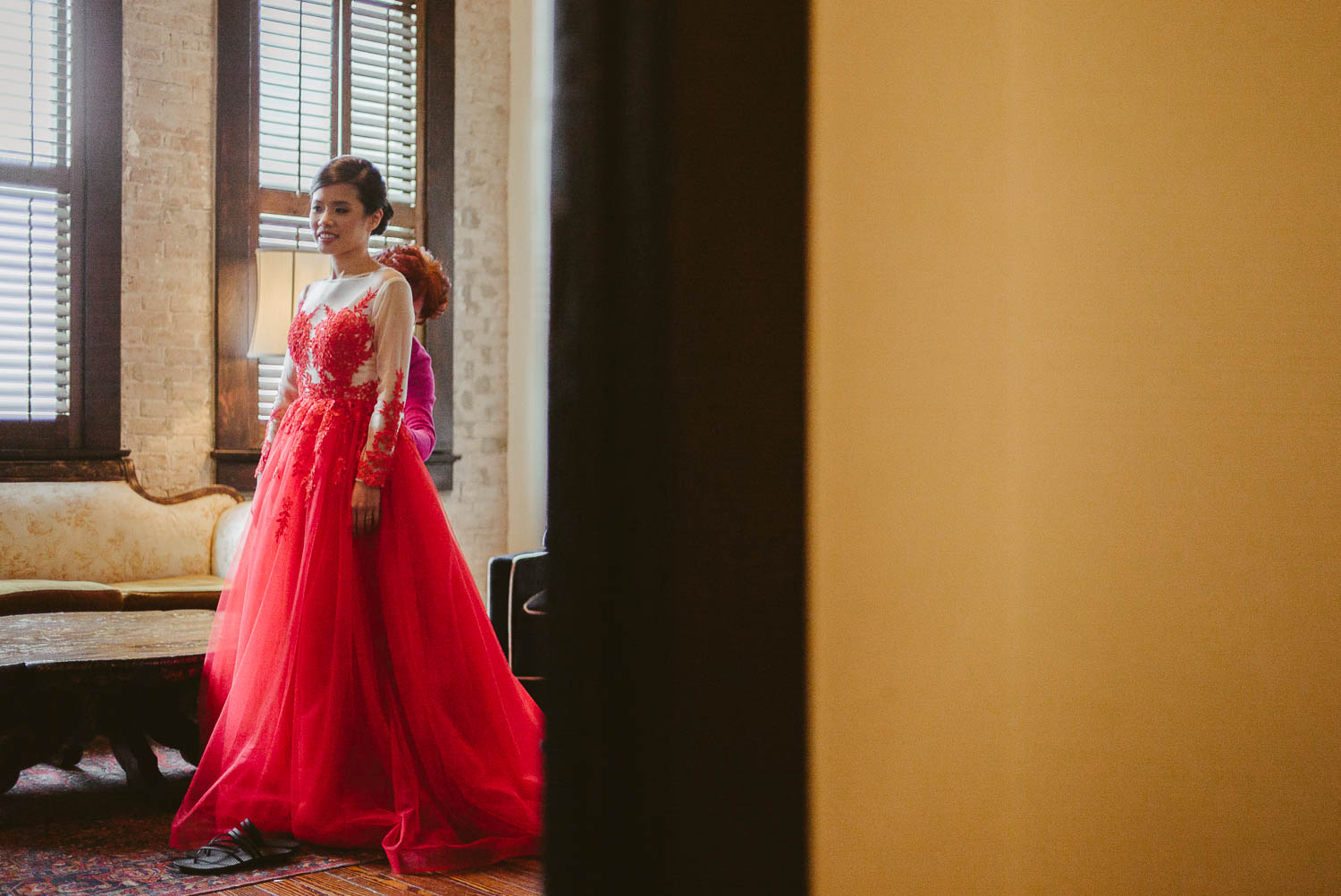 Bride in red dress captured through door frame at Hotel Havana, San Antonio, Texas