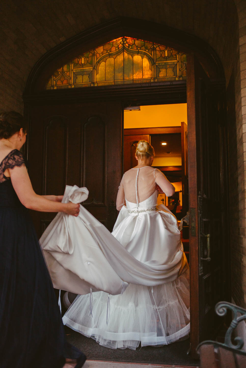 Bridesmaid holds the brides dress at United Methodist Church, Houston, Texas