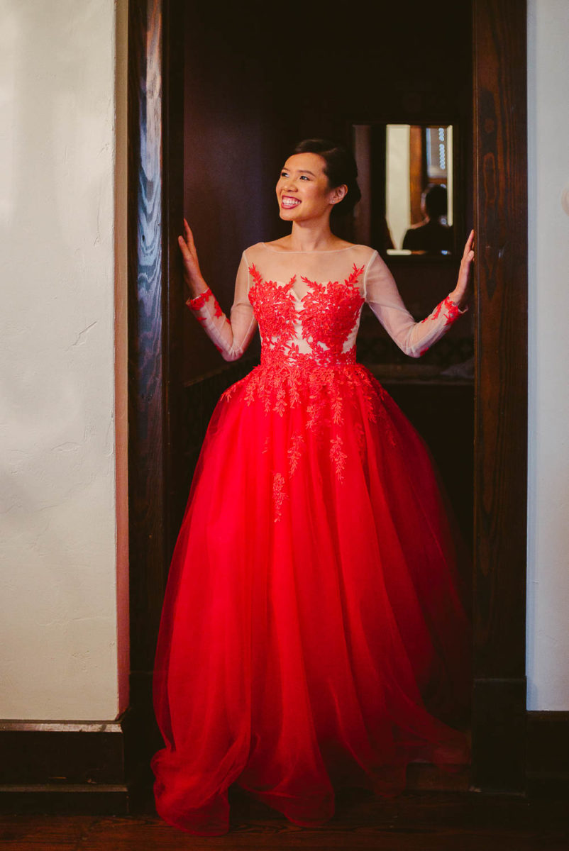 Bride of Taiwan descent in gorgeous red dress in door frame of Hotel Havana -Leica photographer-Philip Thomas Photography