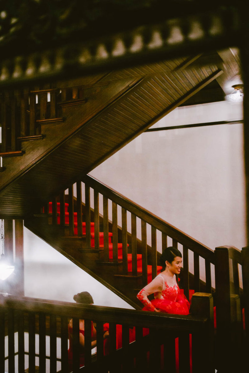 Bride in beautiful red dress ascends a staircase at Hotel Havana -Leica photographer-Philip Thomas Photography