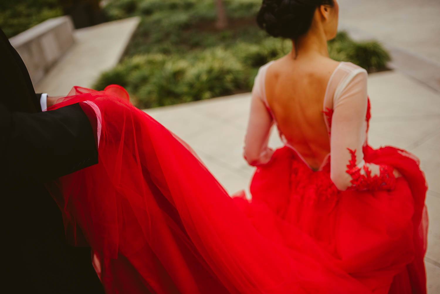 Shot with groom holding the end of beautiful red wedding dress at Hotel Havana -Leica photographer-Philip Thomas Photography