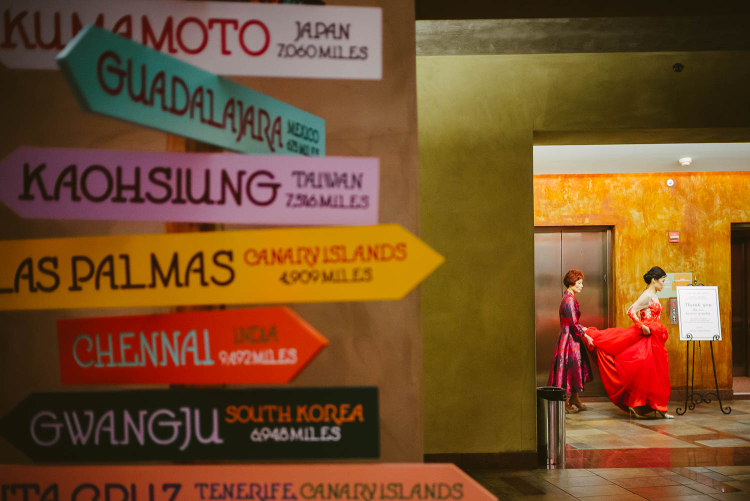 Bride arrives with Taiwan mother with signages in foreground of image at La Orilla Del Rio Ballroom-Leica photographer-Philip Thomas Photography