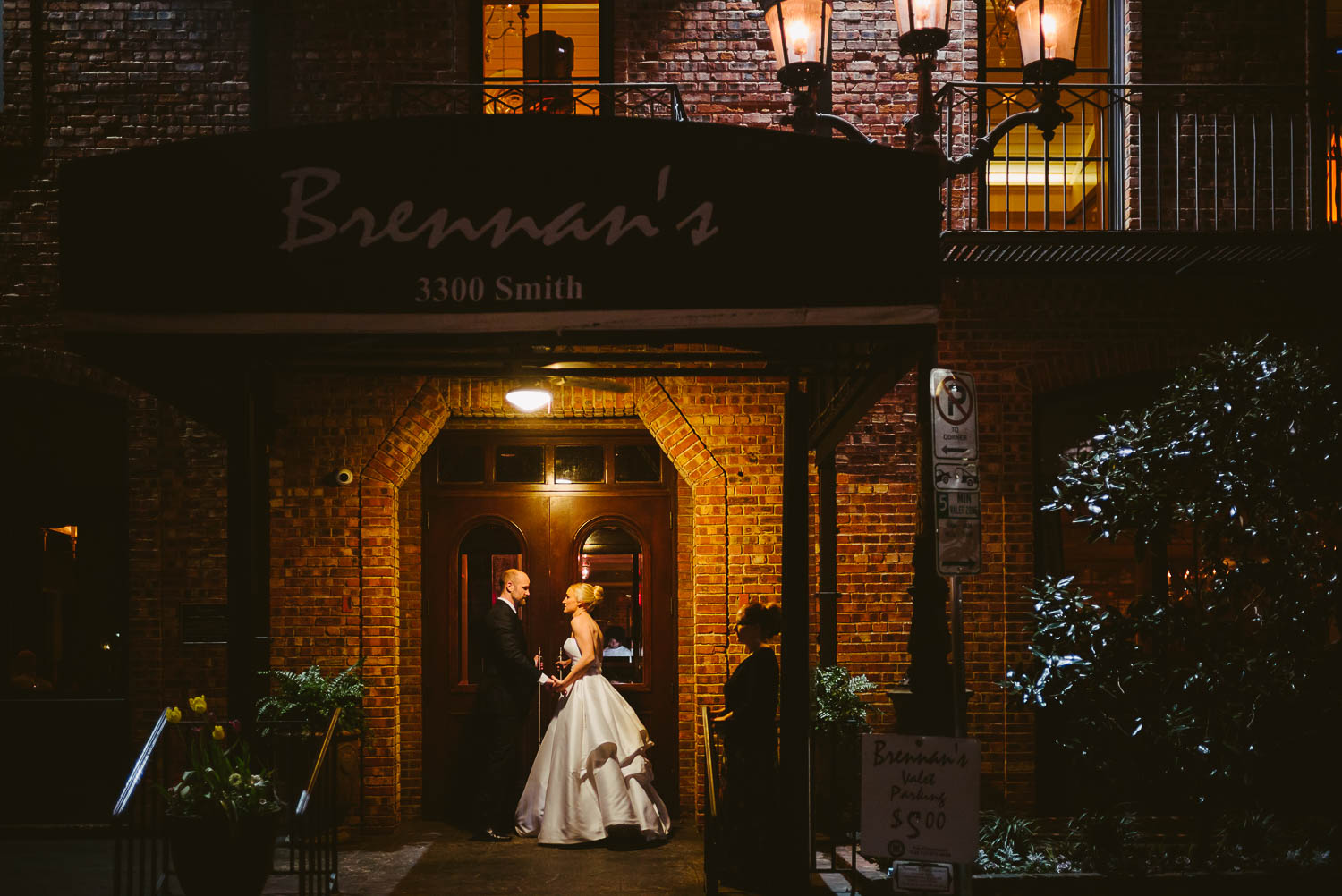 Couple arrive ready to walk through the entrance wedding reception Brennan's of Houston, Texas.