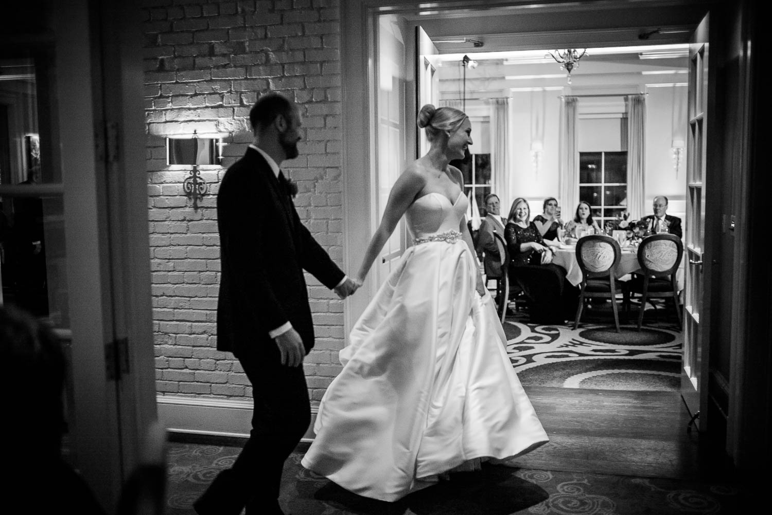 The wedding reception entrance as couple holds hands wedding reception Brennan's of Houston, Texas.