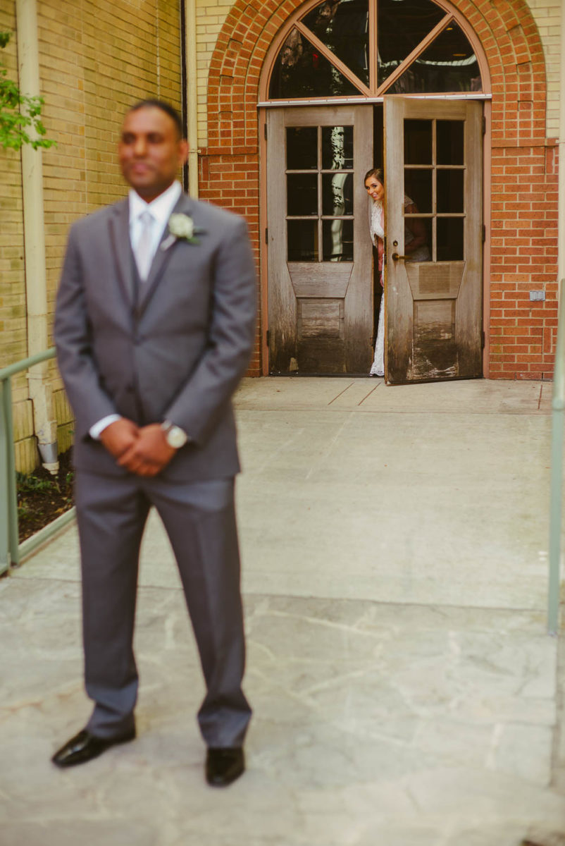 Bride sees groom as she peeks through door first look at The Witte Museum San Antonio Texas