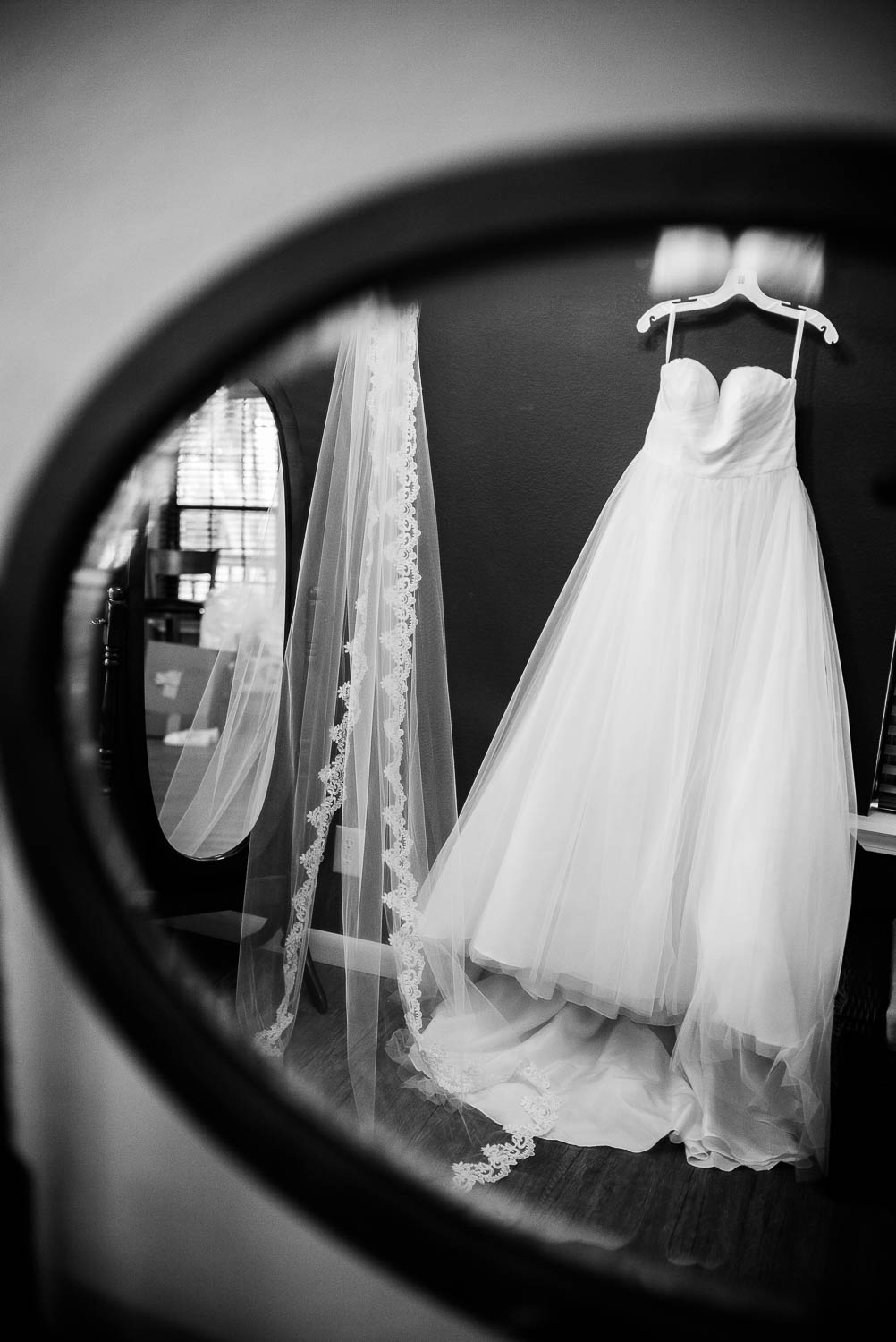 Brides dress hangs reflected in a mirror The Gardens of Old Town Helotes Hill Country Wedding
