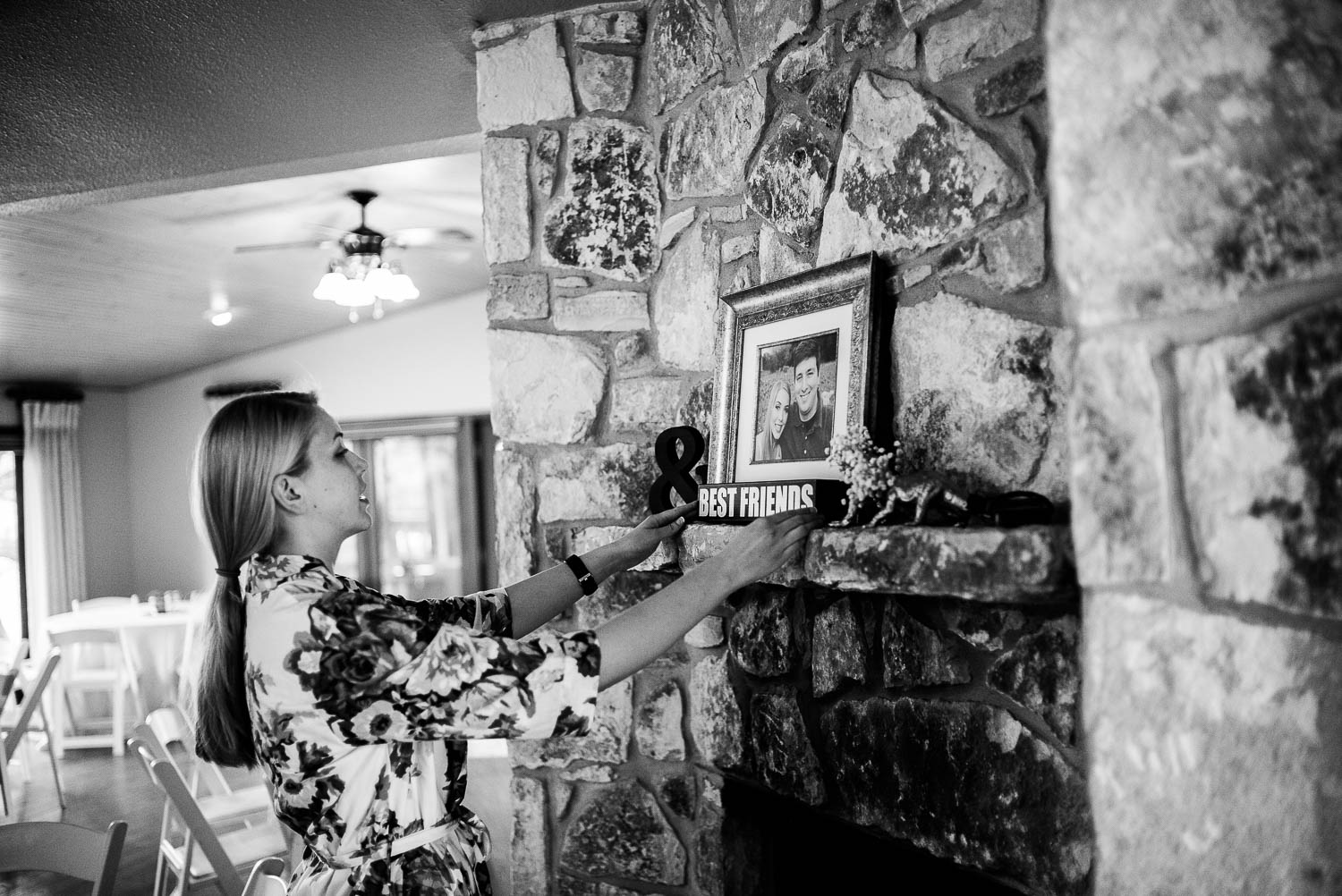 In a DIY wedding bride places a framed photo on fireplace The Gardens of Old Town Helotes Hill Country Wedding