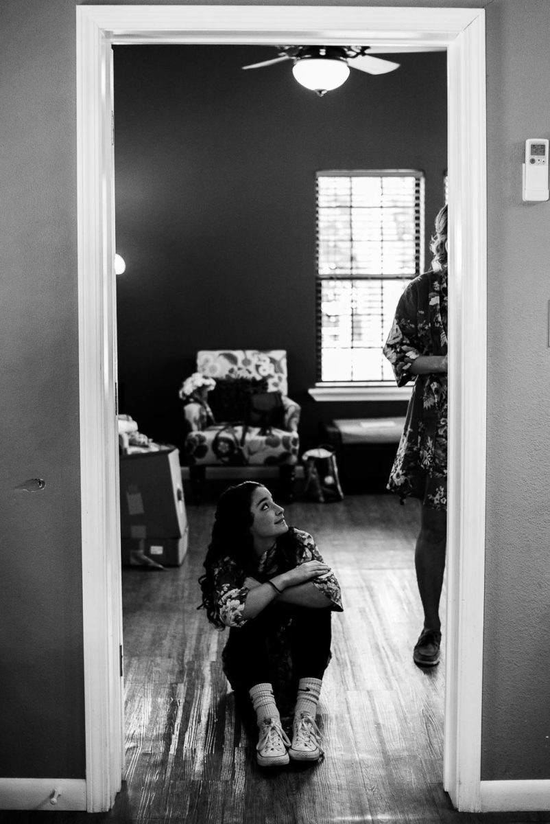 Brides youngest sister looks up in door frame of bridal suite The Gardens of Old Town Helotes Hill Country Wedding