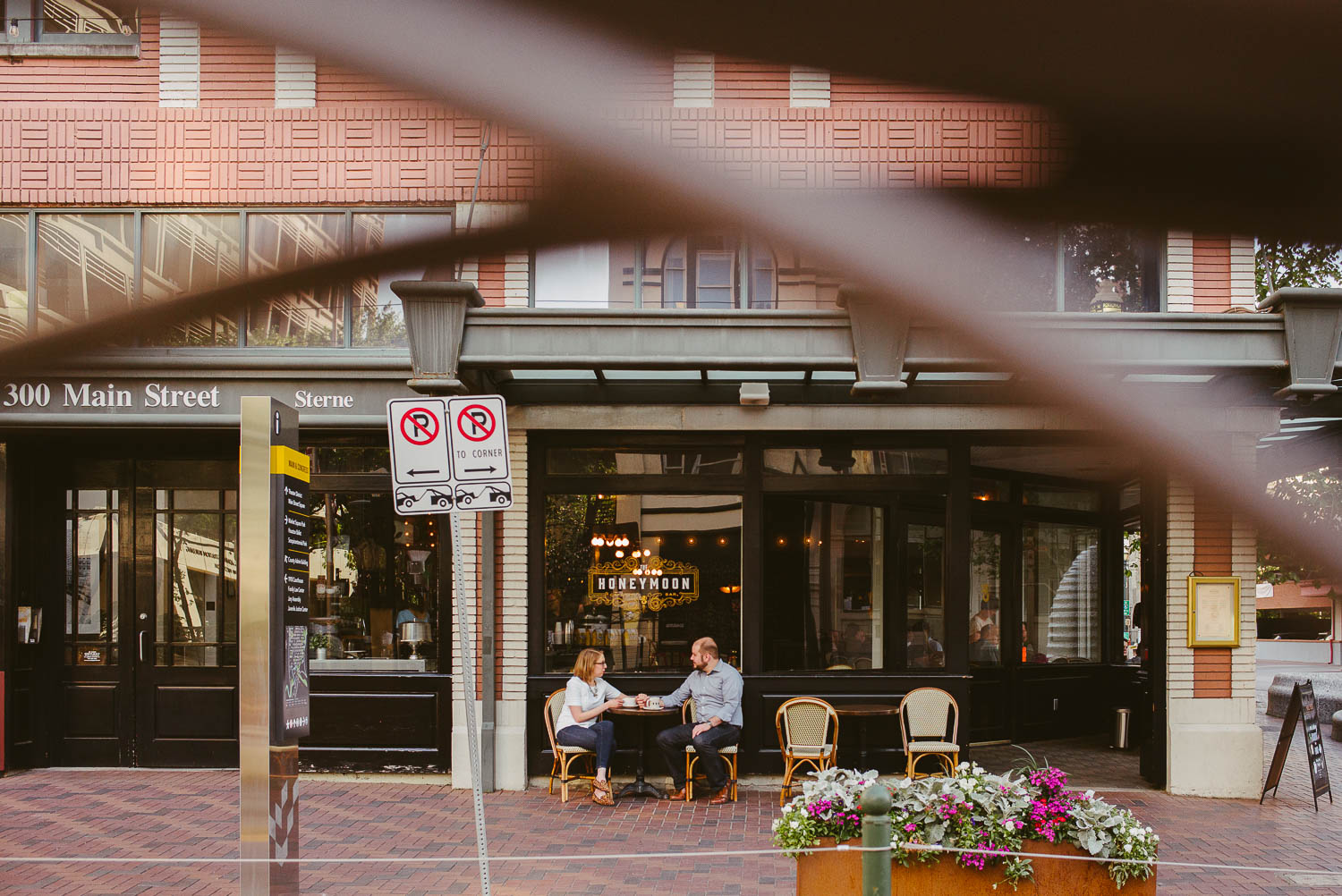 Couple sit drinking coffeee at honeymoon Cafe shot from tram lines Houston-Philip Thomas Photography