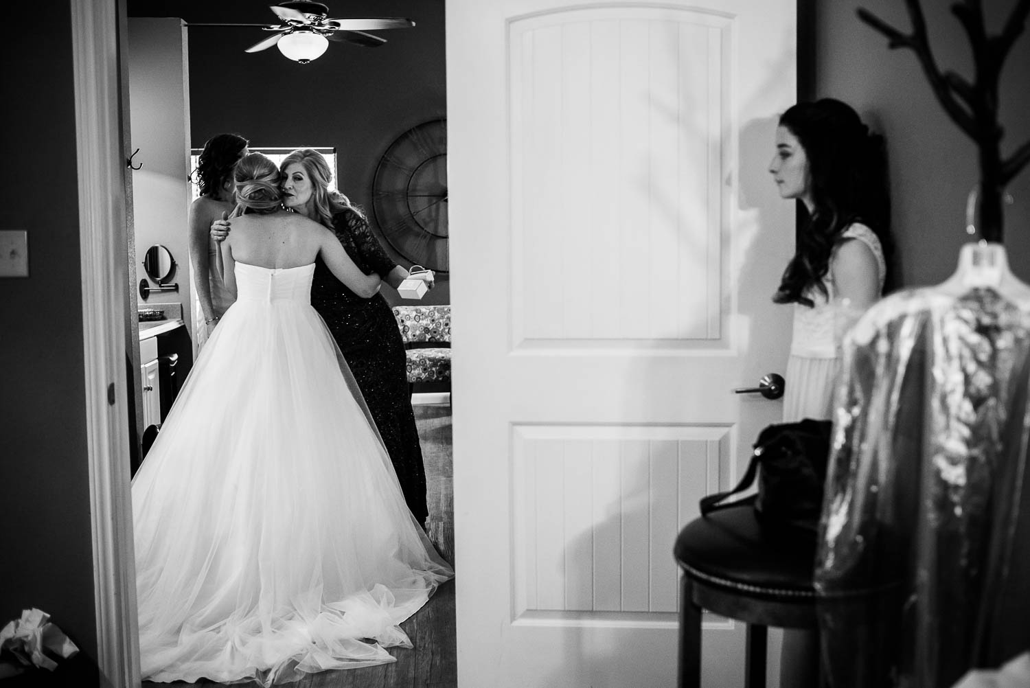 Mother of the groom kisses daughter in law in doorway framing subject moments before wedding ceremony The Gardens of Old Town Helotes Hill Country Wedding
