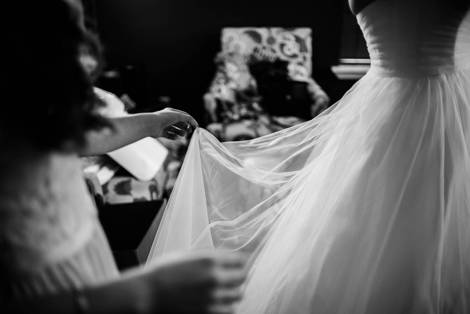 Black and white image of dress and veil held at edge against light -The Gardens of Old Town Helotes Hill Country Wedding