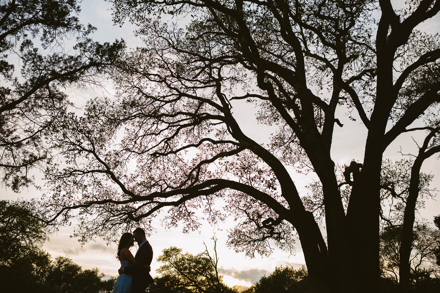 Austin Engagement session Wide angle of couple silhouetted at Balcones District Park Austin Engagement Downtown