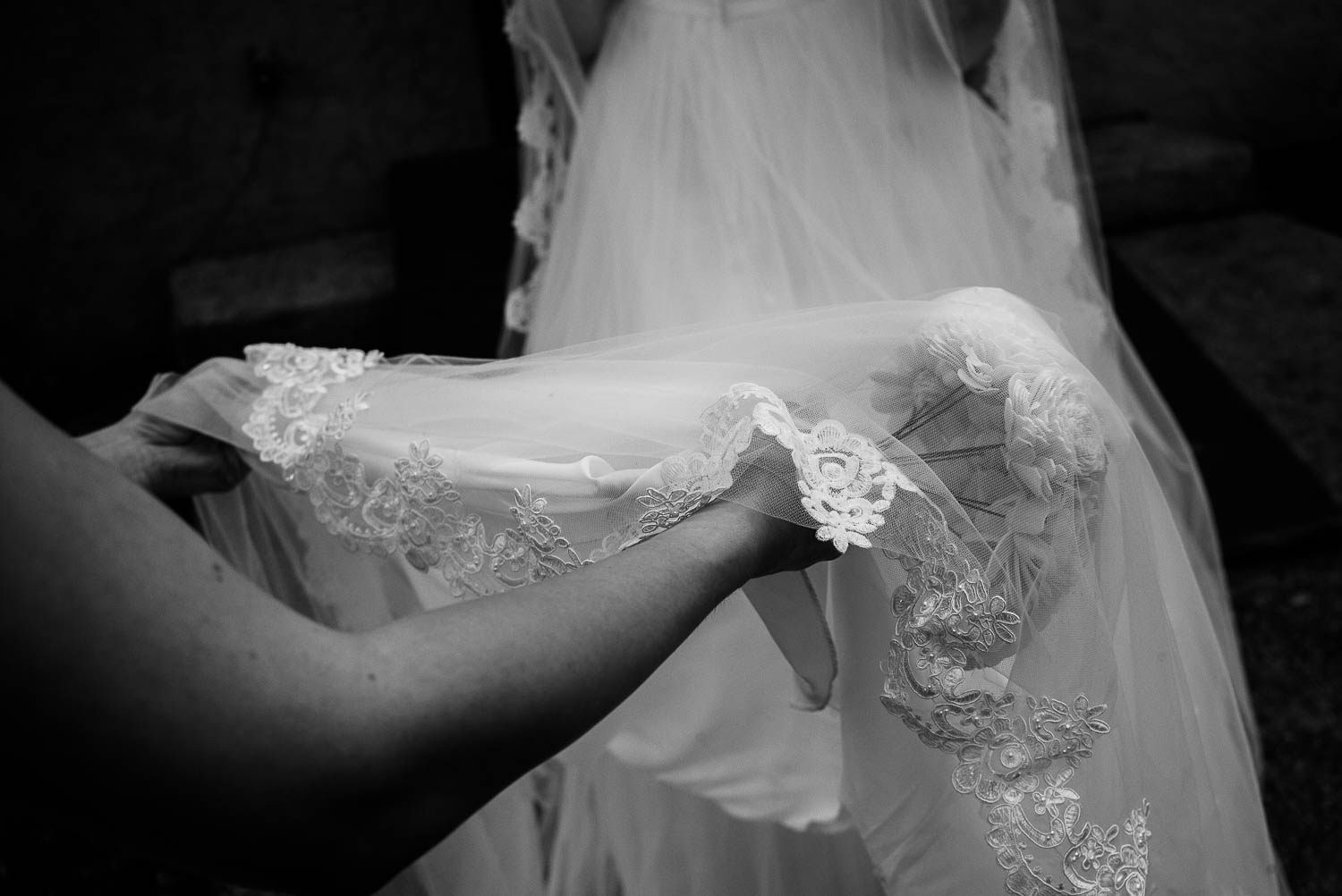 Holding the brides dress close up in monochrome The Gardens of Old Town Helotes Hill Country Wedding