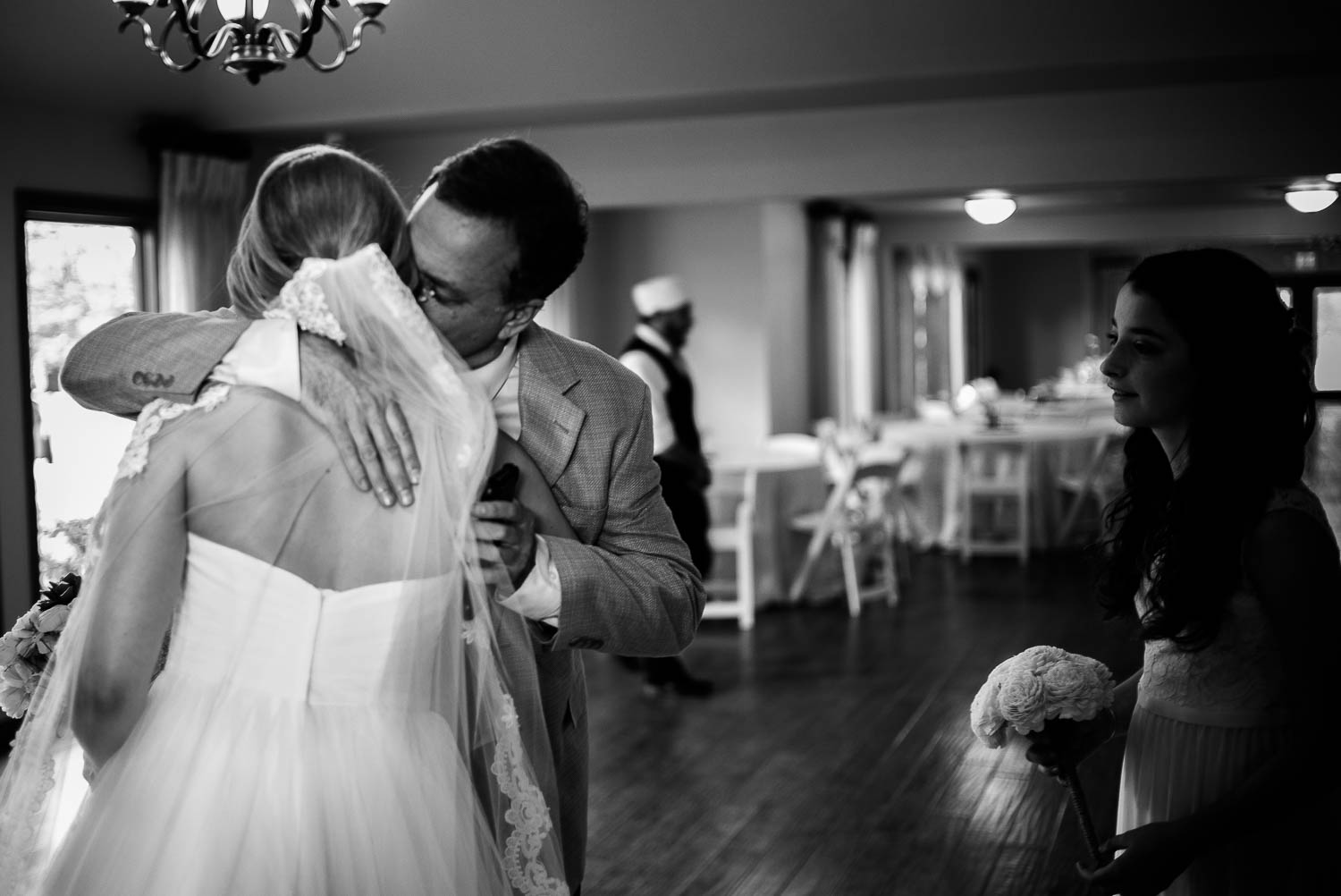 Father of the bride sees daughter for the first time and hugs as youngest sister observes The Gardens of Old Town Helotes Hill Country Wedding