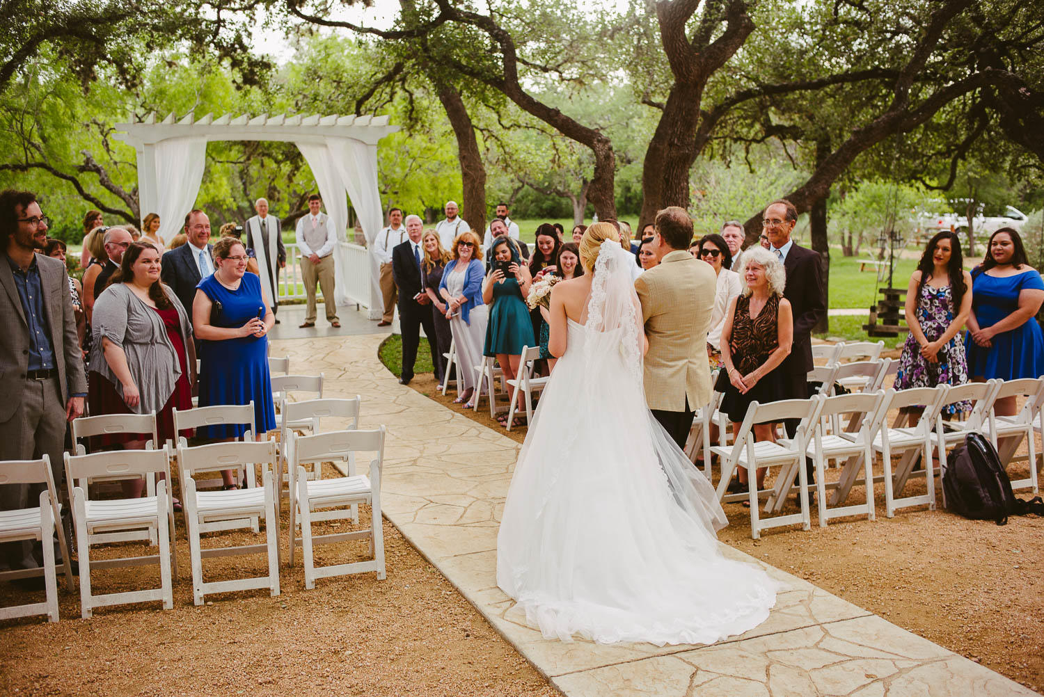 Father of the bride and daughter walk down the aisle The Gardens of Old Town Helotes Hill Country Wedding