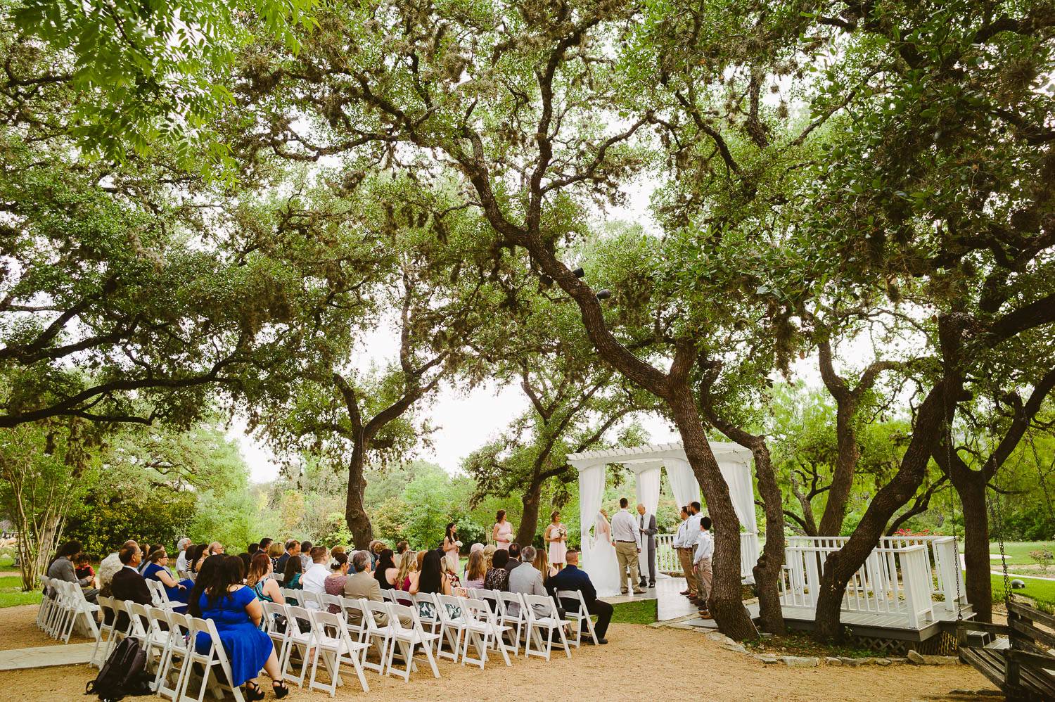 Image shows wide angle of the wedding ceremony and couple with brides grandfather The Gardens of Old Town Helotes Hill Country Wedding