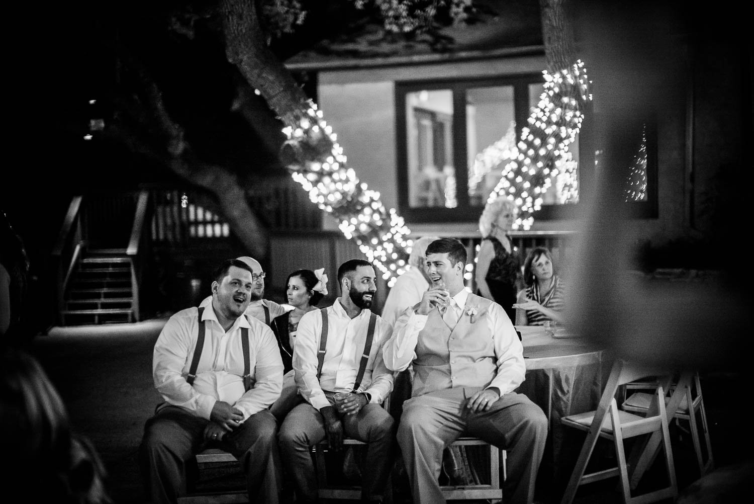 Groom and groomsmen sit and share jokes at The Gardens of Old Town Helotes Hill Country Wedding