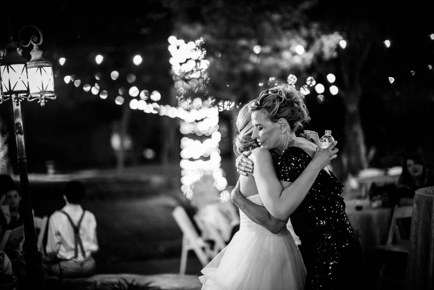 Mother and daugher hug moments before departing wedding reception The Gardens of Old Town Helotes Hill Country Wedding