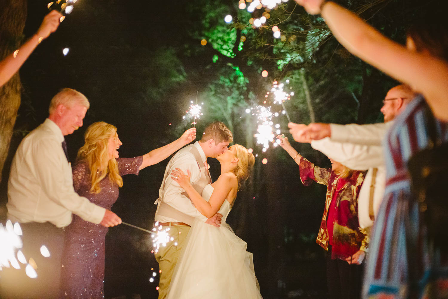 Jessica and Jeff kiss under sparklers -The Gardens of Old Town Helotes Hill Country Wedding