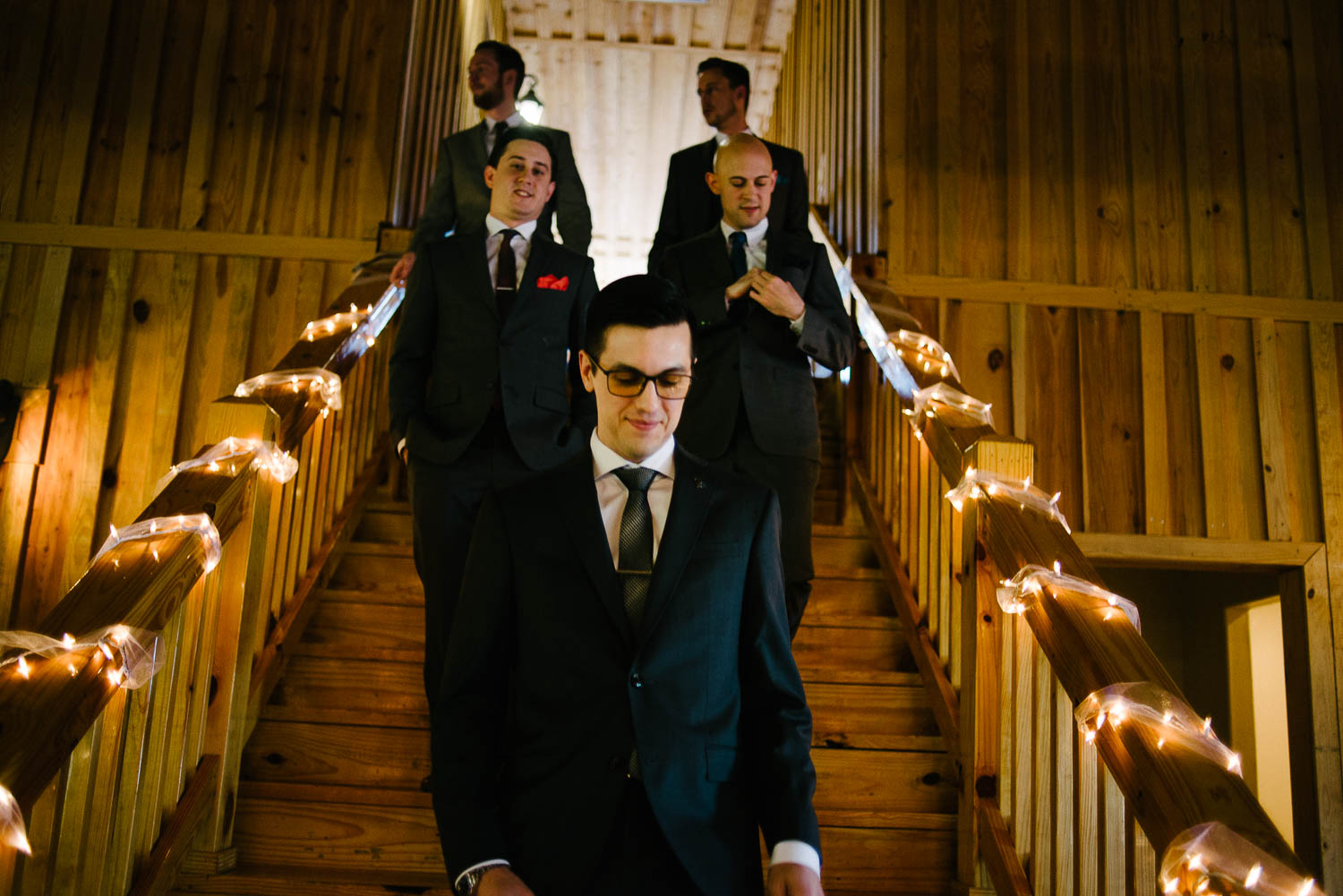 Groom and groomsmen walk down stairs amd commence walk to ceremony Pecan Springs Houston Texas photo by Philip Thomas Photography