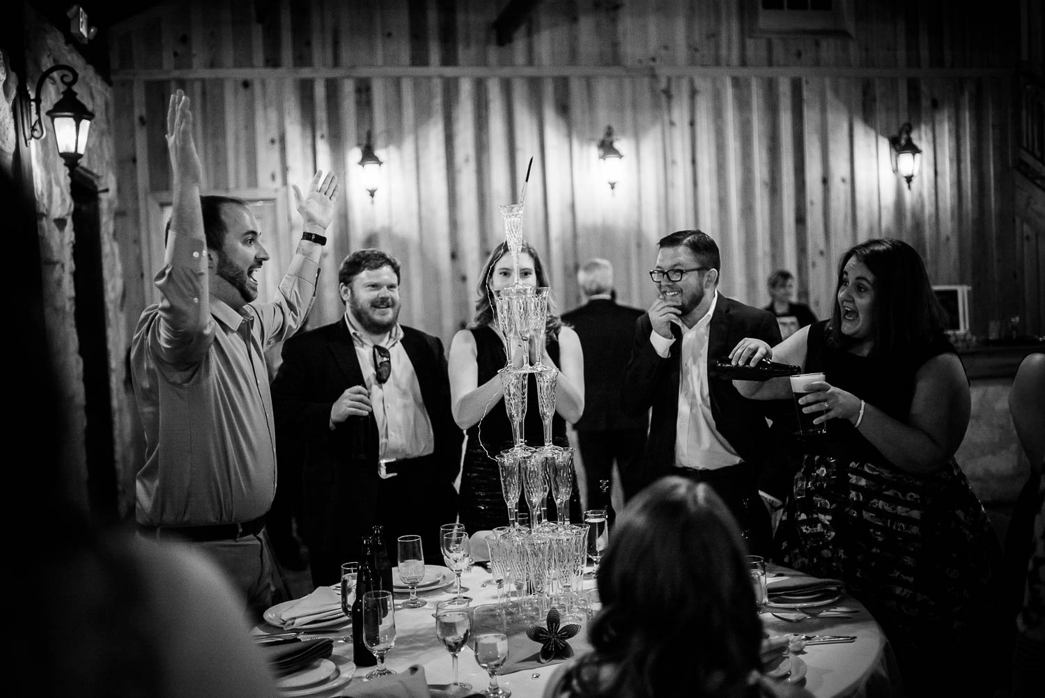 Champagne glasses are stacked shows reaction of wedding guests at Pecan Springs Houston Texas photo by Philip Thomas Photography