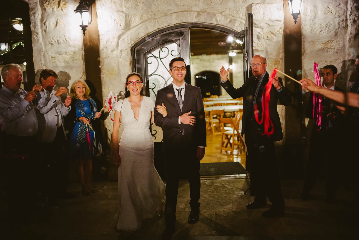 Couple depart reception with bubbles blow from guests at Pecan Springs Houston Texas photo by Philip Thomas Photography