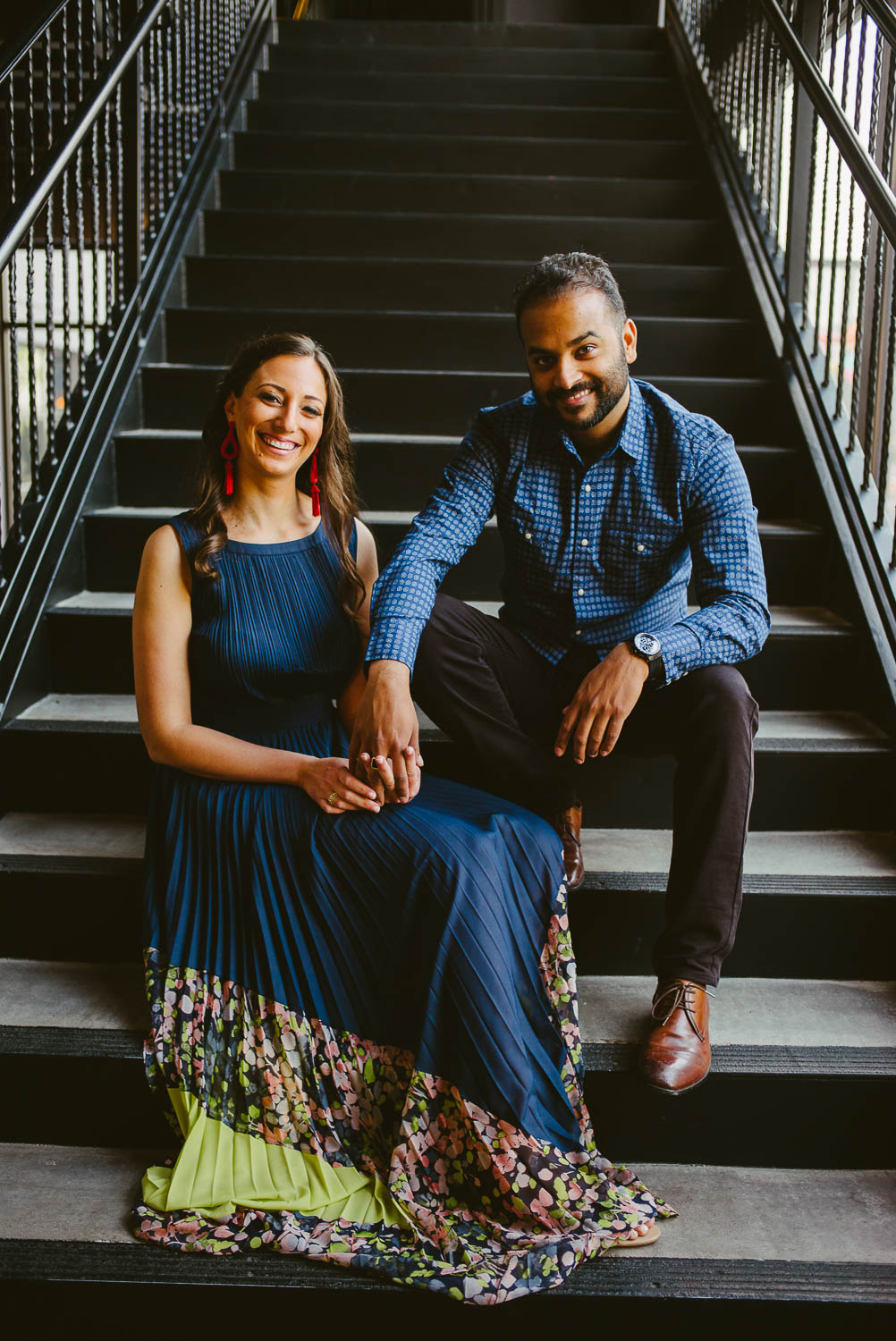 Couples engagement session sit on staircase at The Astorian, Houston texas
