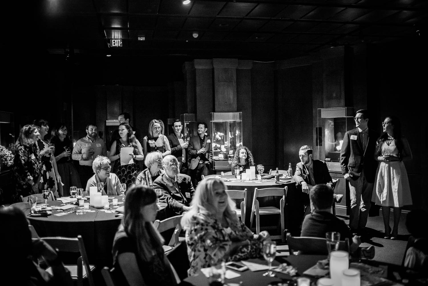 Couple enjoy toasting with friends and family at Rehearsal dinner dinosaur image at Houston Museum of Natural Science by Philip Thomas Photography