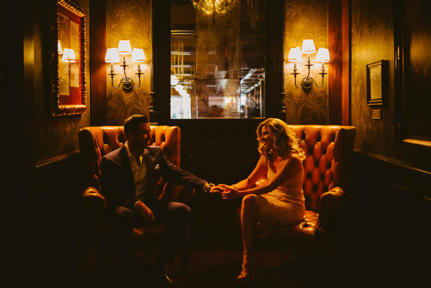 Couple sitting with warm light engagement portrait in Bohanans San Antonio Texas