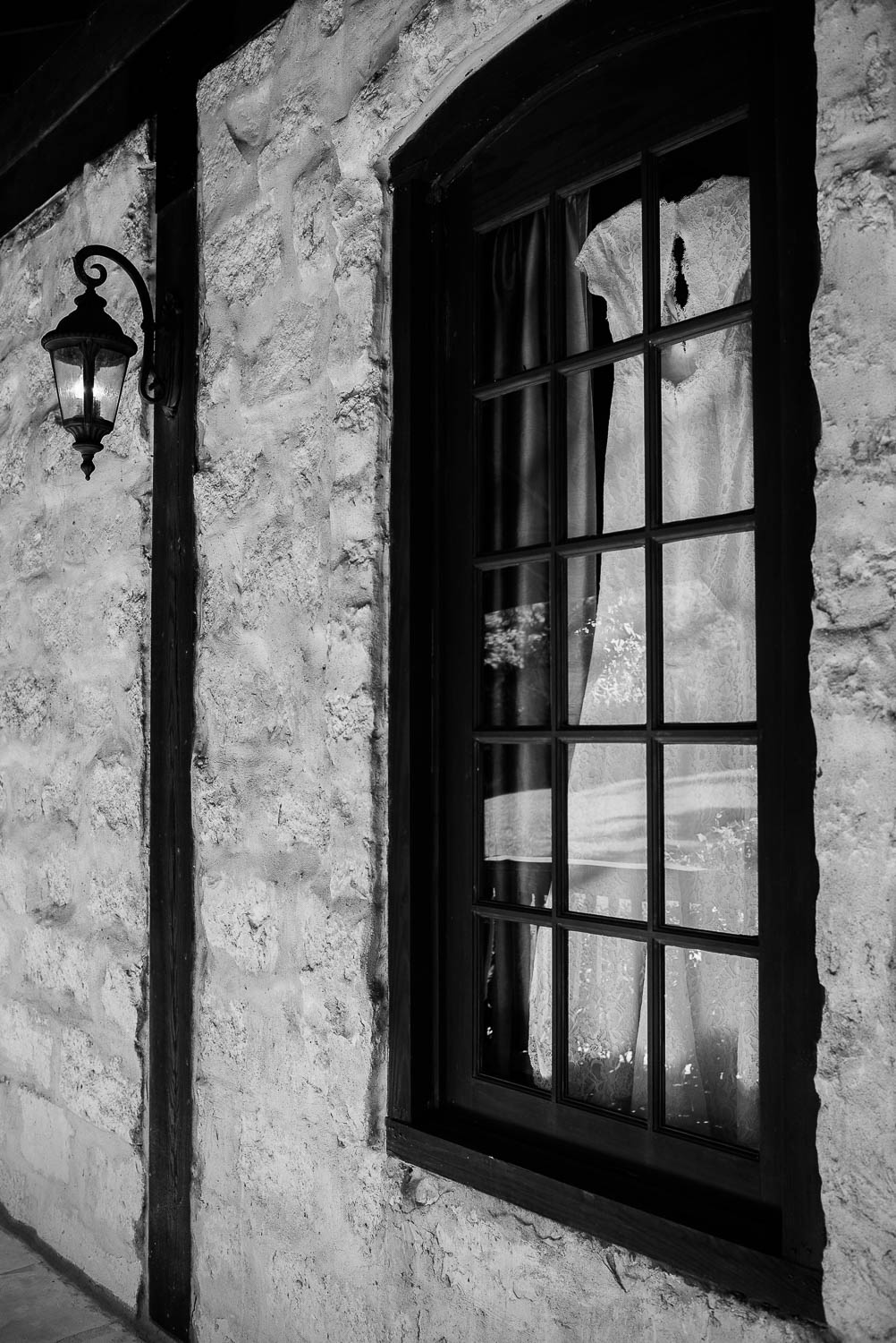 Wedding dress is shown hanging inside window at Pecan Springs Houston Texas photo by Philip Thomas Photography