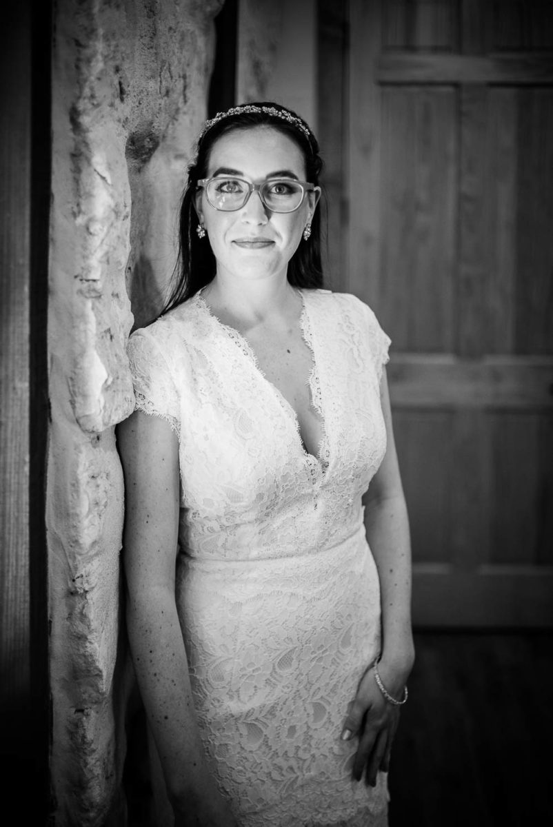 Beautiful Bri the bride stands by a window portrait at Pecan Springs Houston Texas photo by Philip Thomas Photography