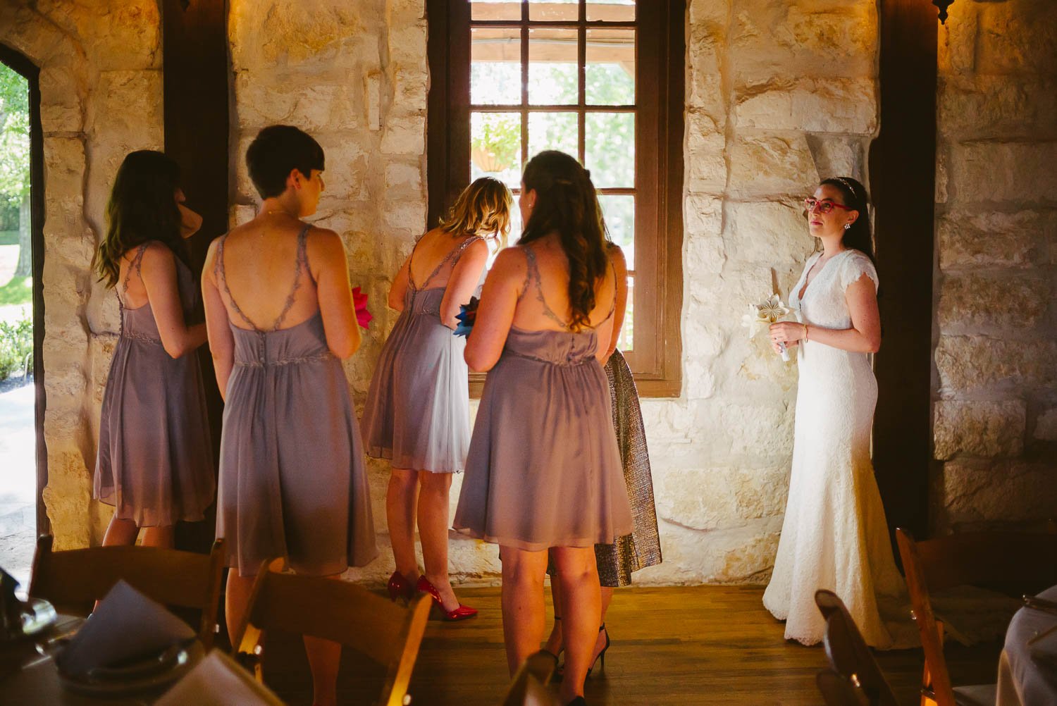 Bridesmaid and bride wait by window pre ceremony at Pecan Springs Houston Texas photo by Philip Thomas Photography