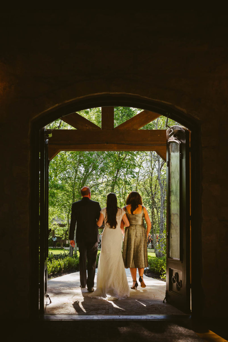 Bri mother and father walk down the aisle through door wedding venue Pecan Springs Houston Texas photo by Philip Thomas Photography