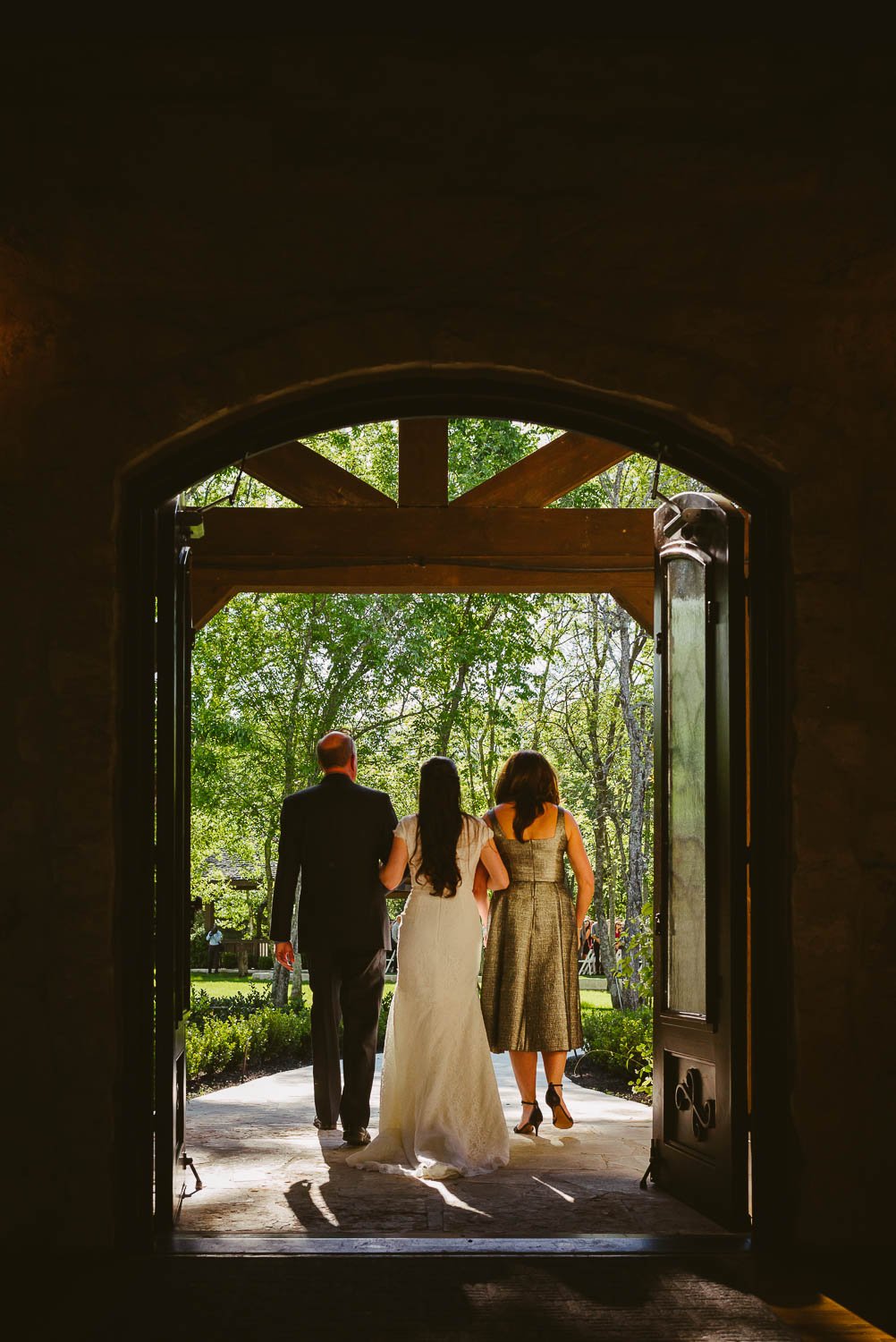 Bri mother and father walk down the aisle through door wedding venue Pecan Springs Houston Texas photo by Philip Thomas Photography