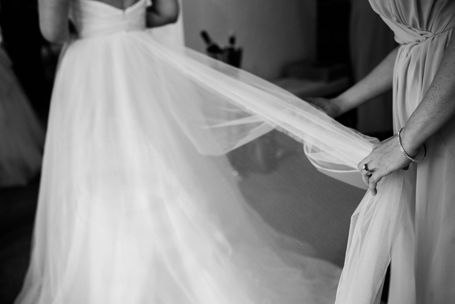 A bridesmaid assists the bride with her veil at Bell Tower on 34th Houston-Leica wedding photographer-Philip Thomas Photography