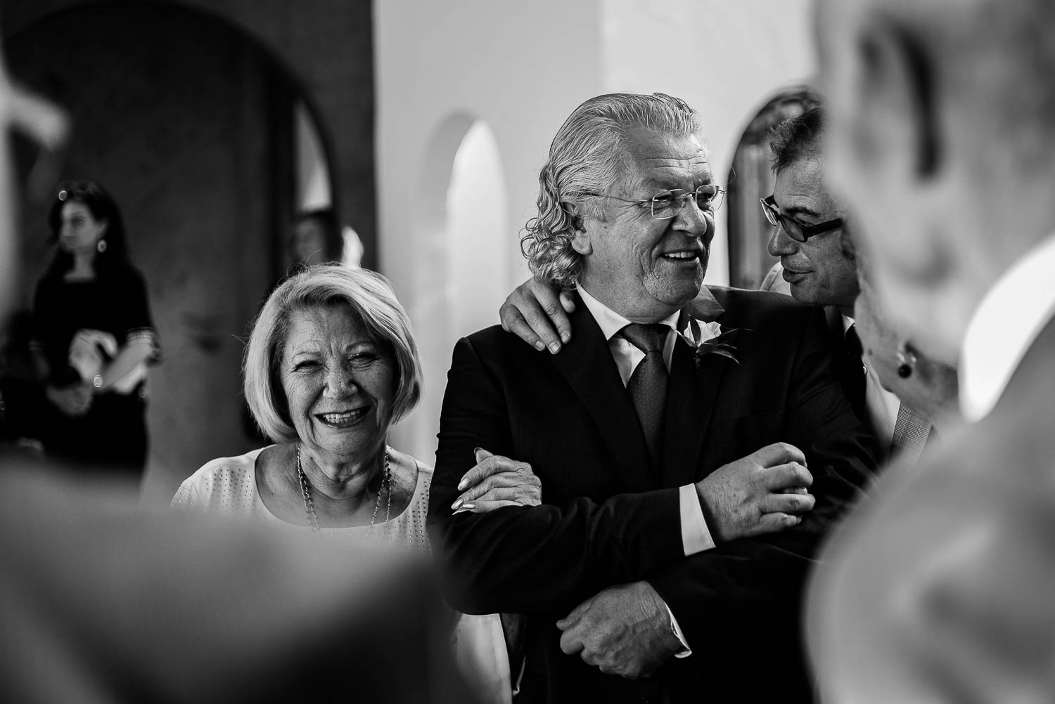 Father and mother of the groom share a nervous laugh with another guest before wedding ceremony -Bell Tower on 34th Houston-Leica wedding photographer-Philip Thomas Photography