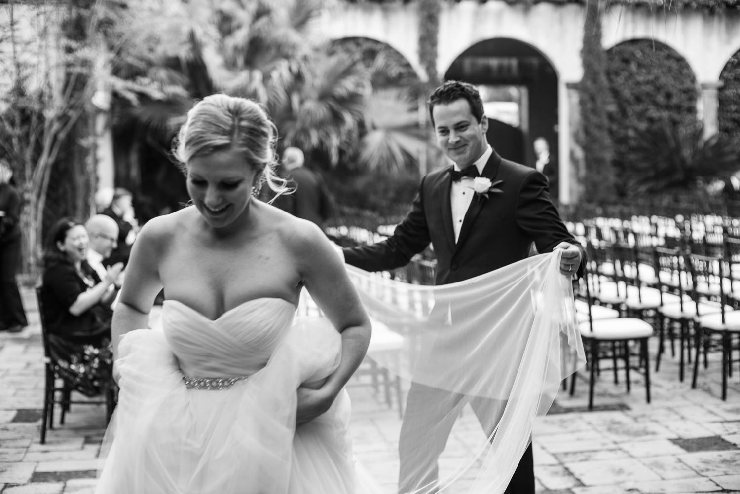 The groom picks up and carries the brides long veil train Bell Tower on 34th Houston-Leica wedding photographer-Philip Thomas Photography