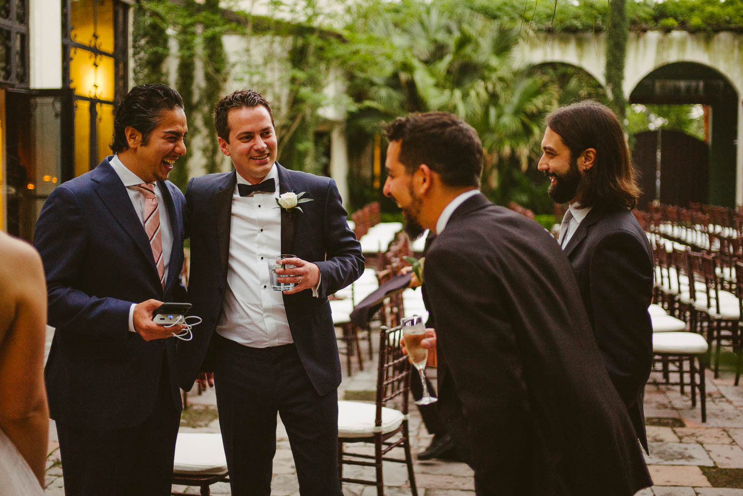 Friends and Italian family share a joke at a cocktail party Bell Tower on 34th Houston-Leica wedding photographer-Philip Thomas Photography