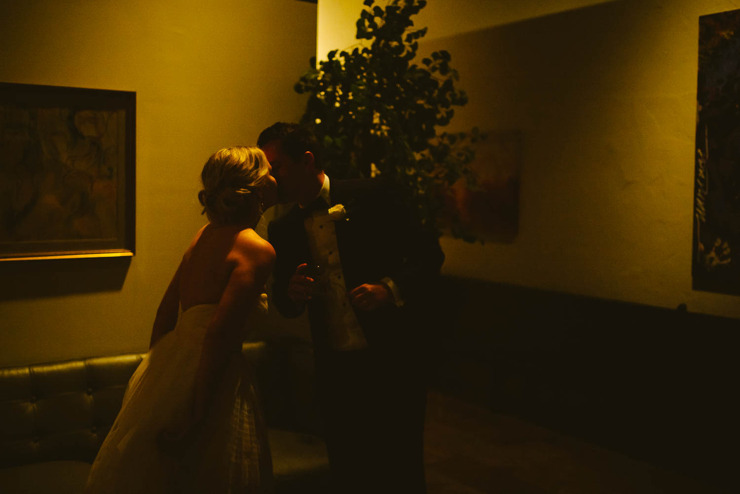 A stolen kiss in low light before wedding reception Bell Tower on 34th Houston-Leica wedding photographer-Philip Thomas Photography